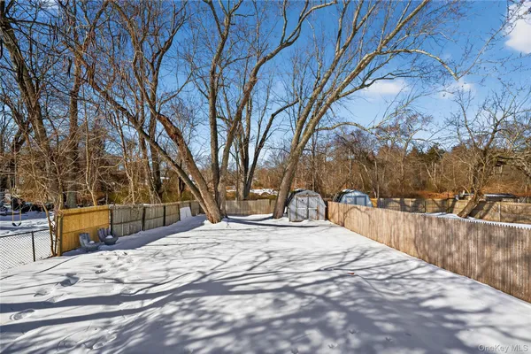 a view of a backyard with snow on the road