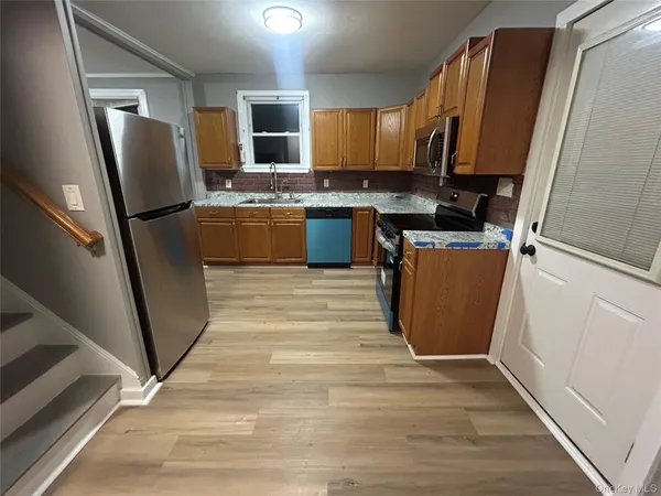 a kitchen with stainless steel appliances a refrigerator a sink a stove top oven a refrigerator and cabinets