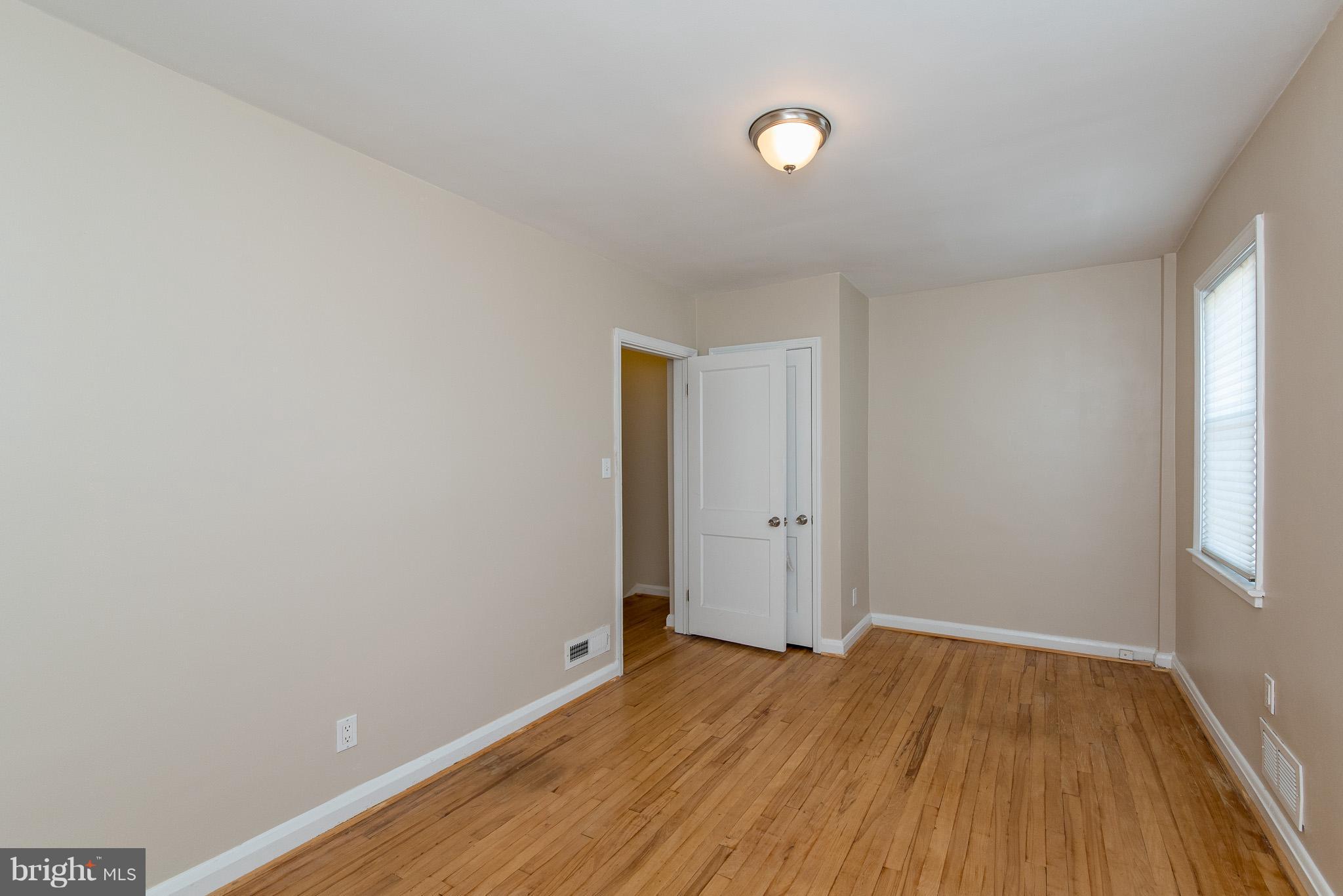 3472 Dunhaven Road Baltimore, MD 21222 - Photo 22 of 30 an empty room with wooden floor and windows