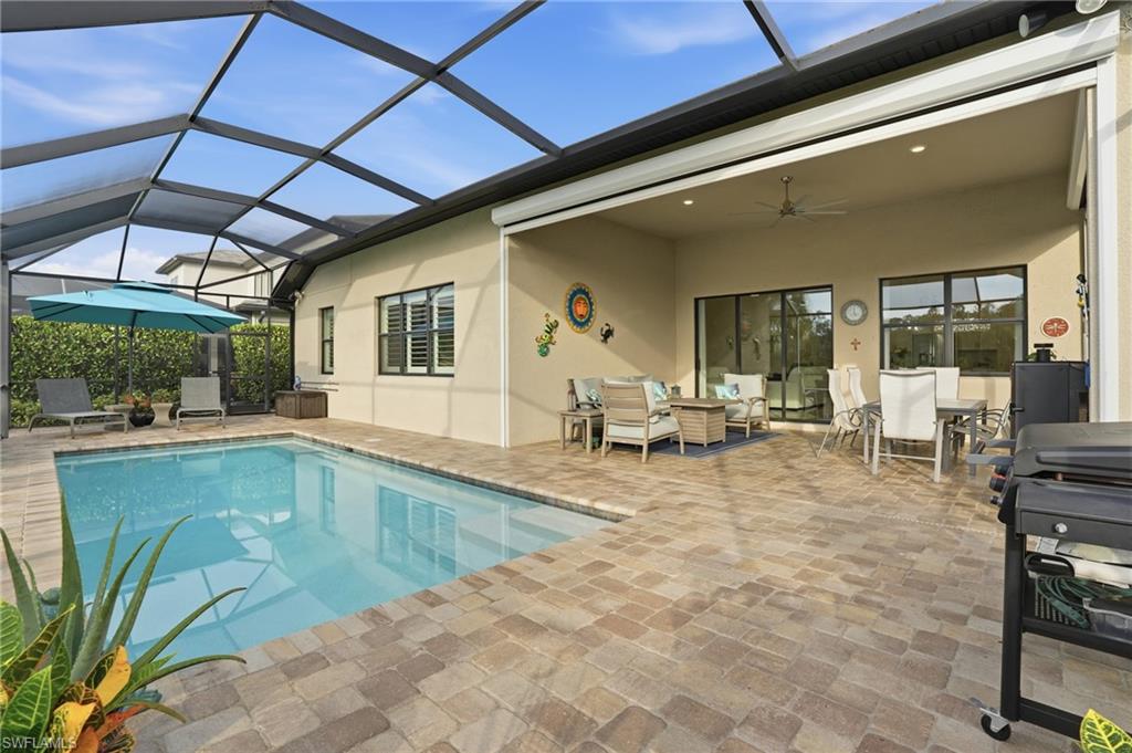 17210 Ashcomb Way Estero, FL 33928 - Photo 34 of 47 a view of a patio with dining table and chairs under an umbrella