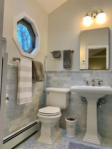 a bathroom with a toilet sink and mirror