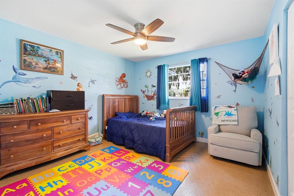 2329 Lime Tree Drive Edgewater, FL 32141 - Photo 13 of 22 a bedroom with a bed and a chandelier