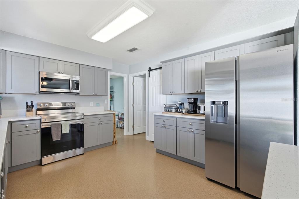 2329 Lime Tree Drive Edgewater, FL 32141 - Photo 9 of 22 a kitchen with stainless steel appliances granite countertop a refrigerator a stove top oven a sink and dishwasher