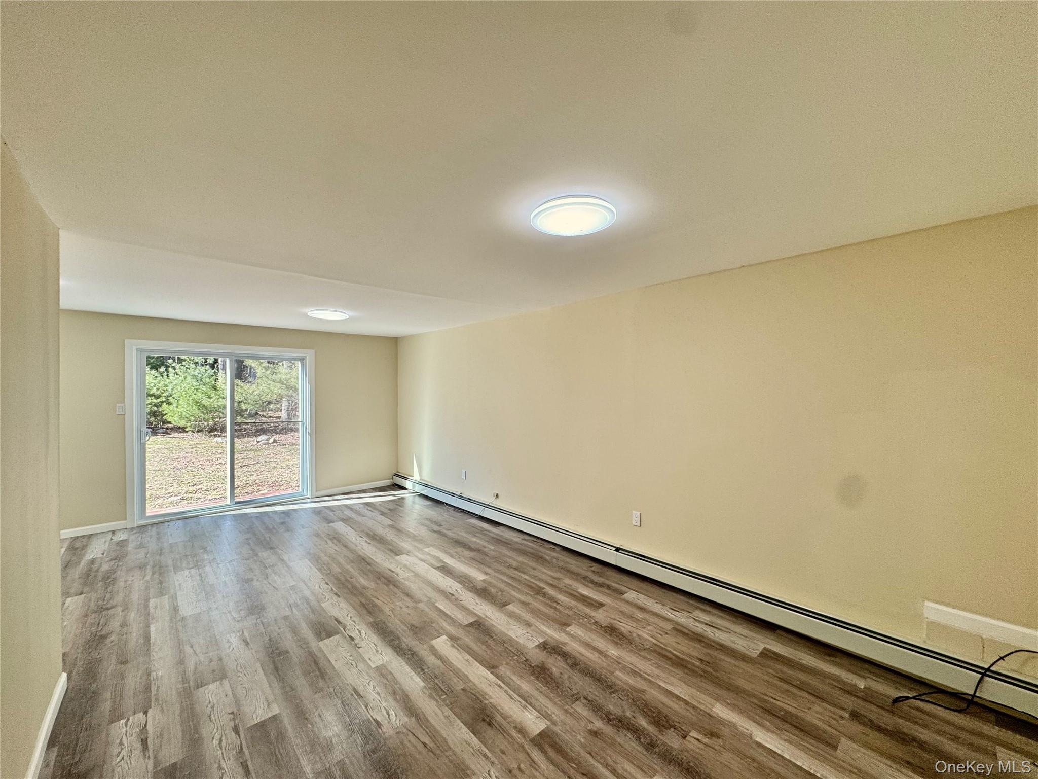 52 Boxbaum Road Sparrowbush, NY 12780 - Photo 3 of 23 an empty room with wooden floor and windows