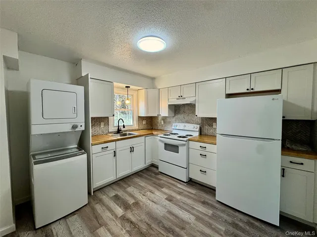 a kitchen with white cabinets and white appliances