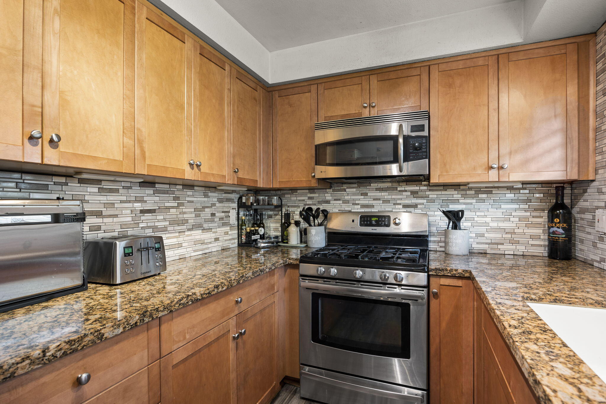 4413 Catlin Circle, Unit B Carpinteria, CA 93013 - Photo 14 of 23 a kitchen with granite countertop a stove a sink and a microwave