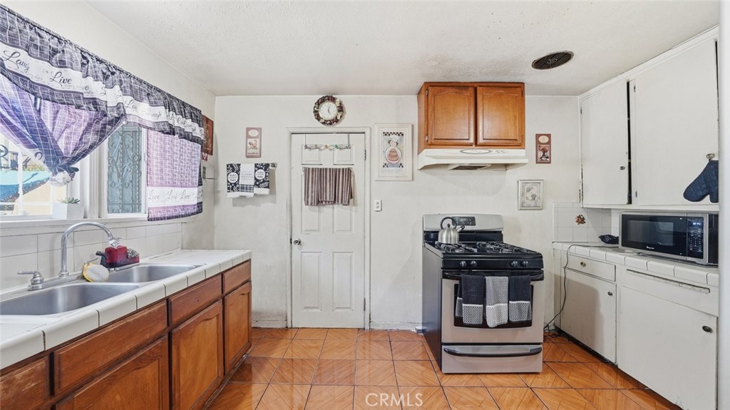 1523 East Vernon Avenue Los Angeles, CA 90011 - Photo 4 of 9 a kitchen with stainless steel appliances a stove a sink and a refrigerator