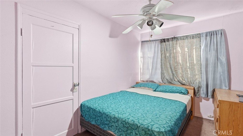 1523 East Vernon Avenue Los Angeles, CA 90011 - Photo 6 of 9 a bedroom with a bed and a chandelier