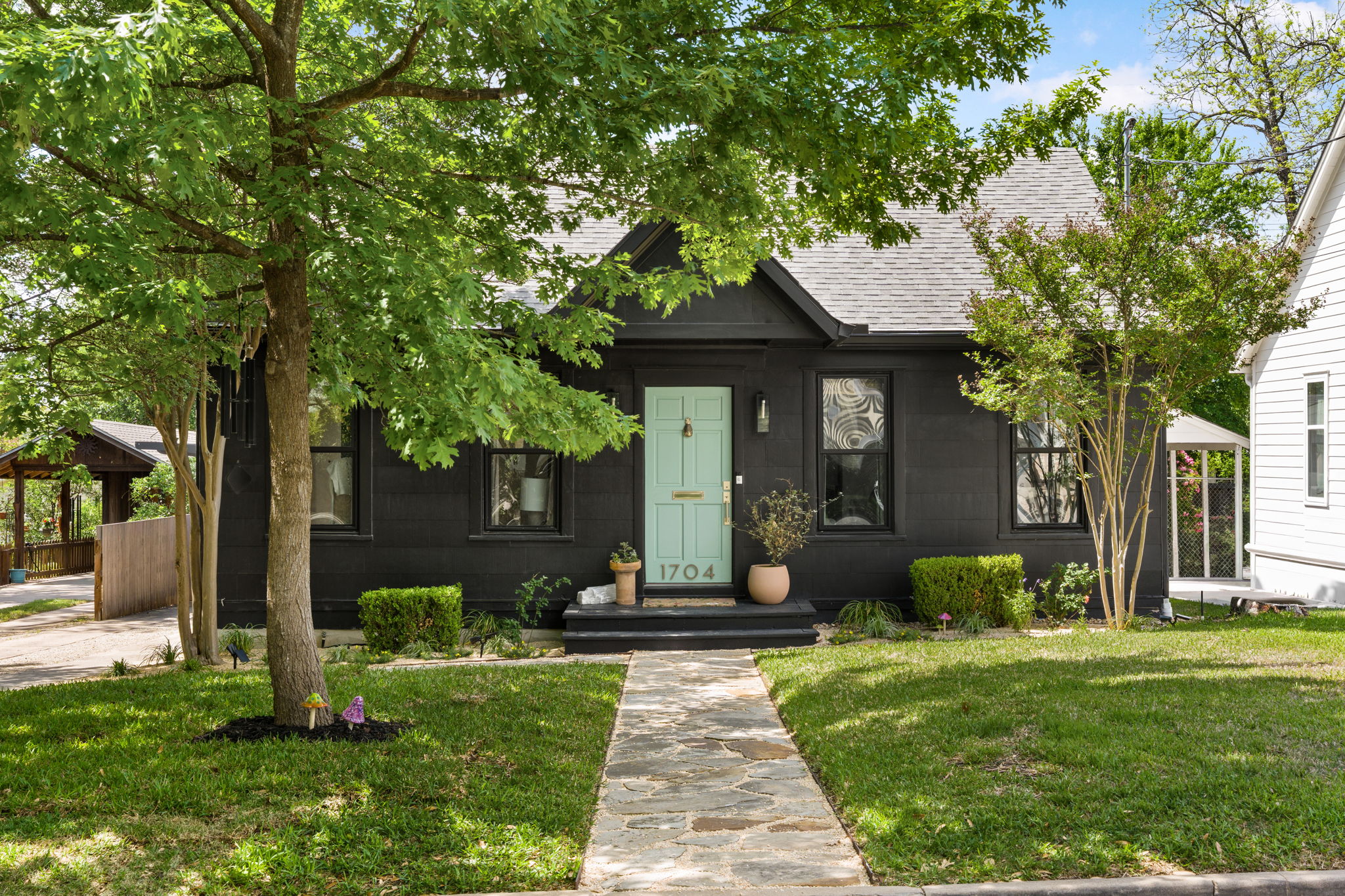 The property features a dark exterior with a contrasting light-colored front door