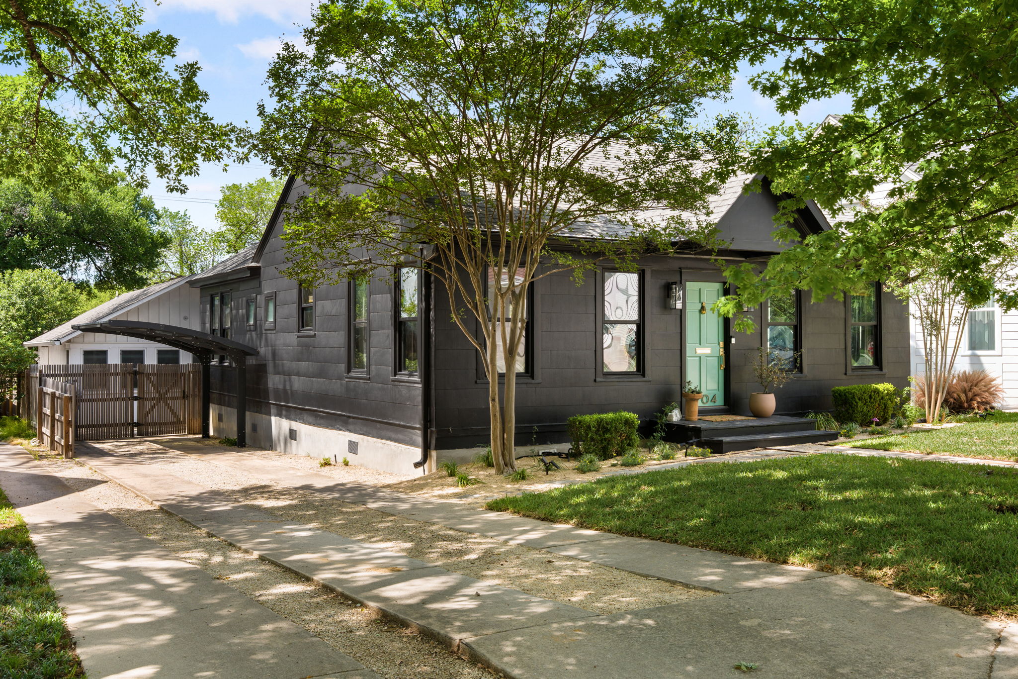 1704 Wethersfield Road Austin, TX 78703 - Photo 2 of 31 The property features a dark-toned exterior with a contrasting light blue entry door