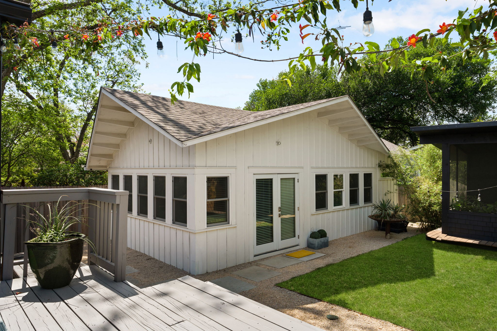 1704 Wethersfield Road Austin, TX 78703 - Photo 24 of 31 The ADU features a white exterior with a light-colored shingled roof, board and batten siding, and several windows