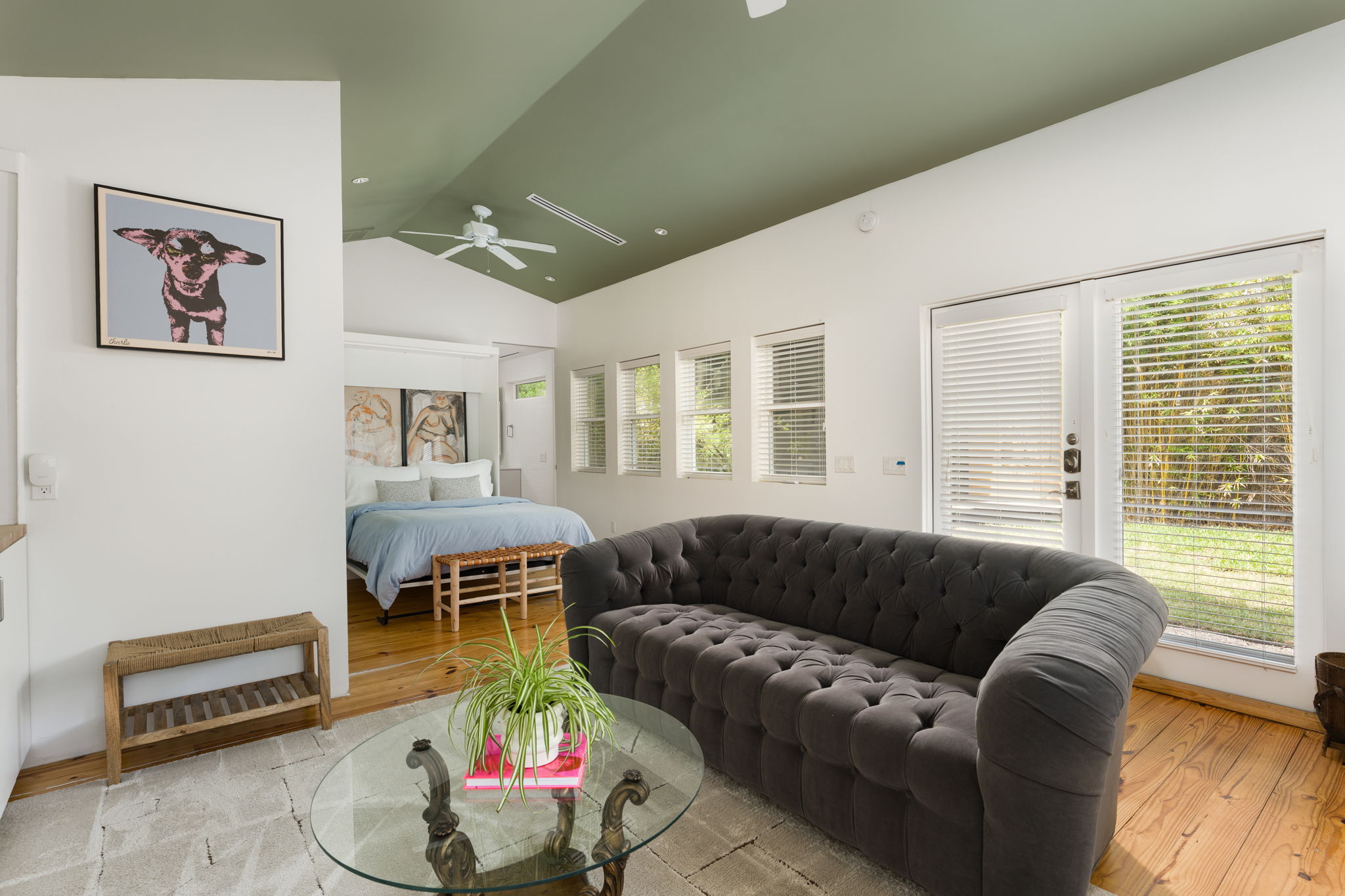 1704 Wethersfield Road Austin, TX 78703 - Photo 27 of 31 The property features a bright living area with vaulted ceilings and a ceiling fan, leading into a bedroom area with hardwood floors