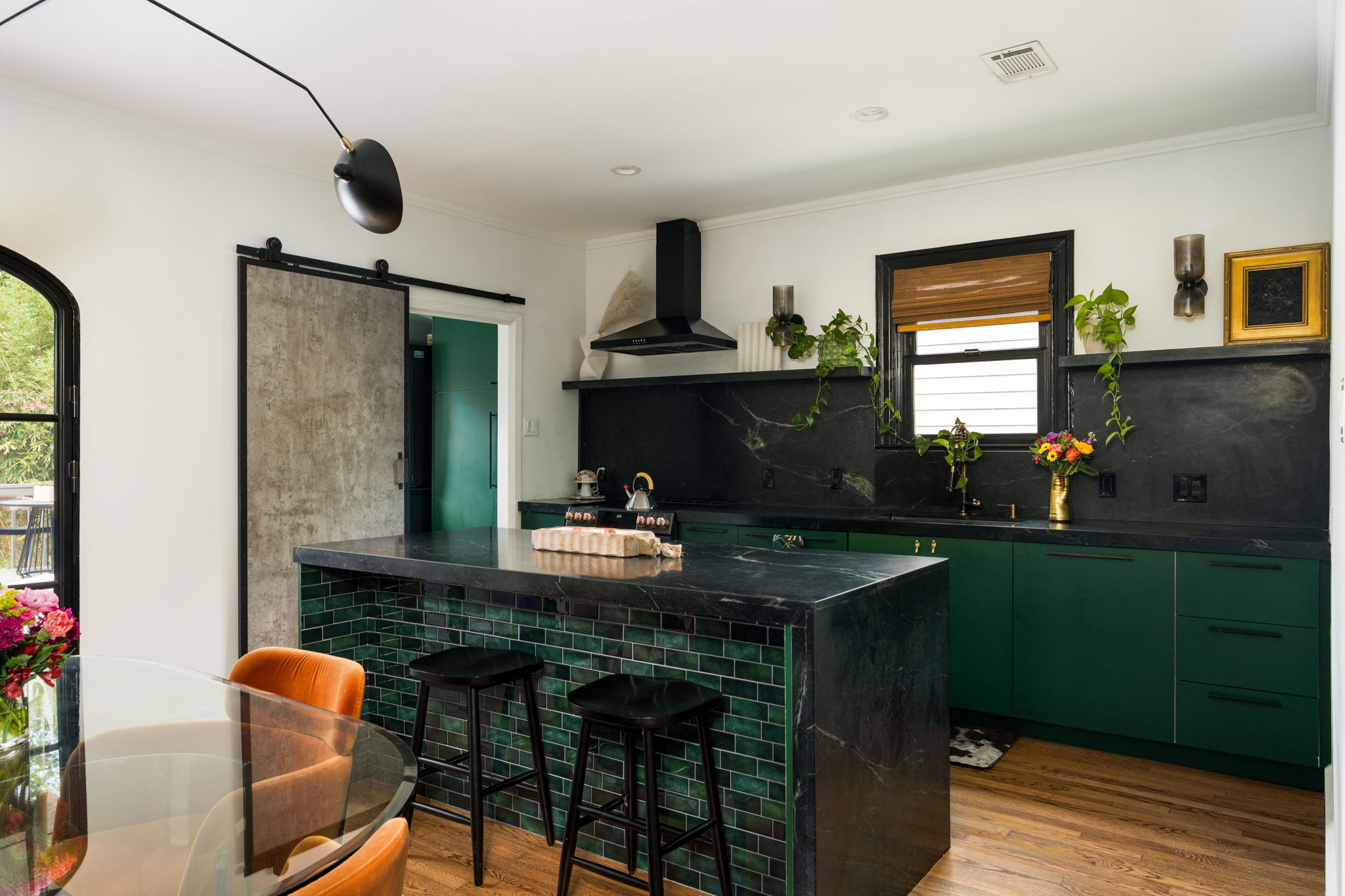 1704 Wethersfield Road Austin, TX 78703 - Photo 10 of 31 The kitchen features a striking black island with a tiled base, green cabinetry, and black soapstone countertops