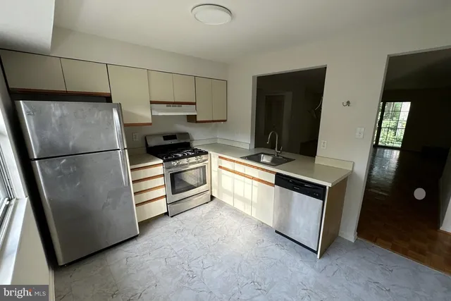 a kitchen with stainless steel appliances a refrigerator sink and microwave