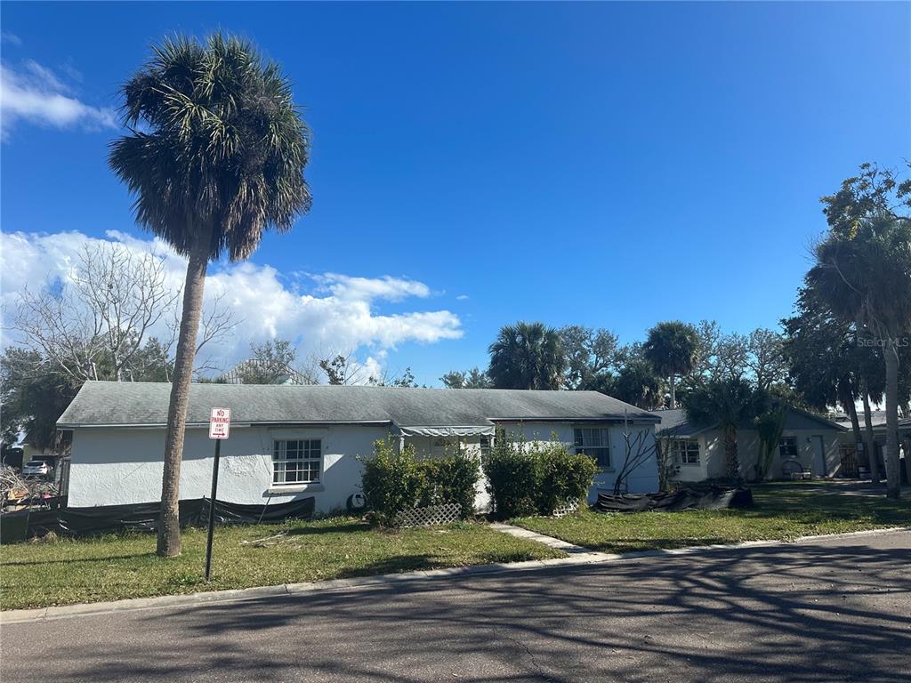 1811 2nd Street Indian Rocks Beach, FL 33785 - Photo 1 of 12 a view of a white house with a big yard and potted plants