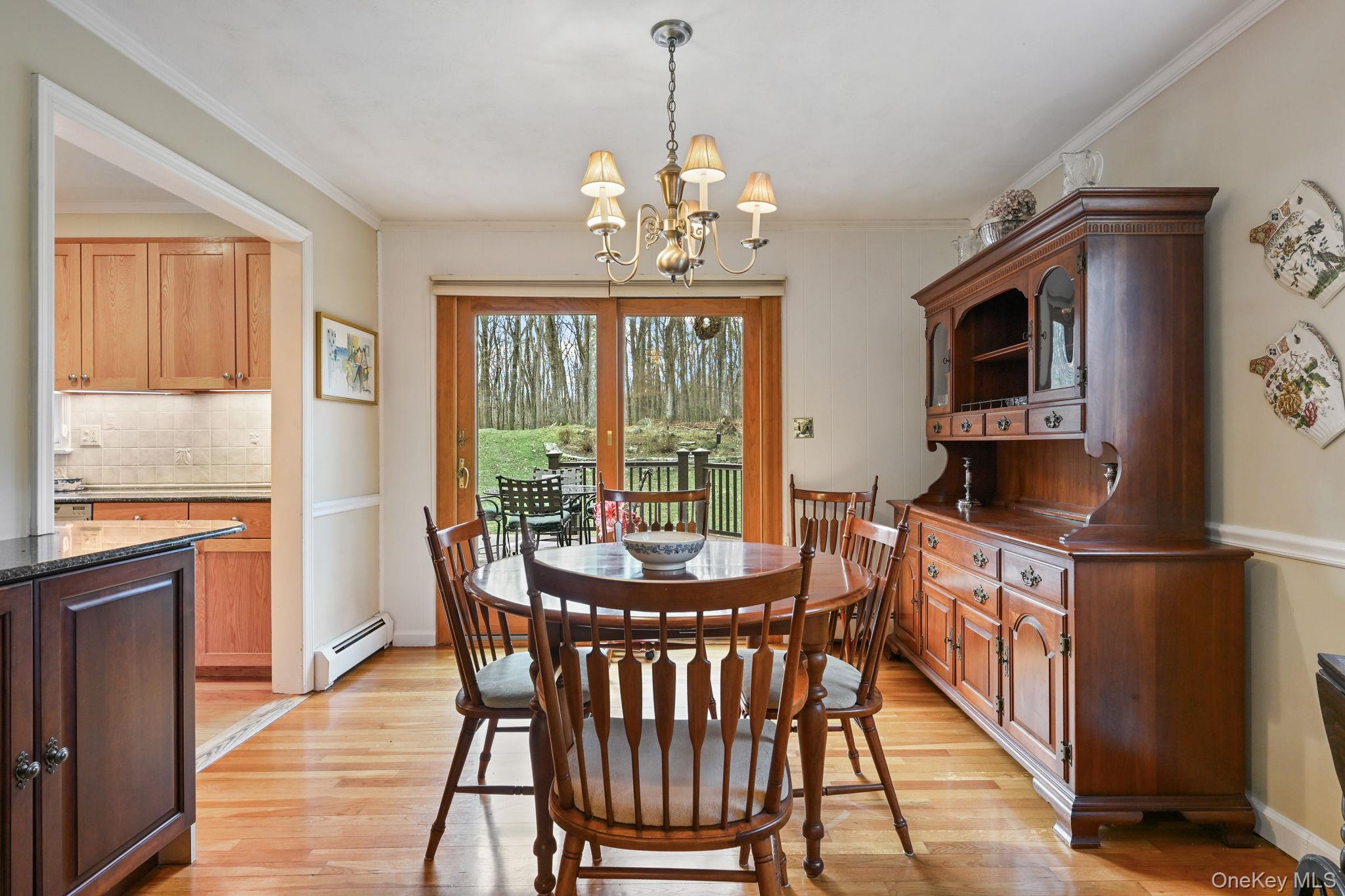 54 Lockwood Road South Salem, NY 10590 - Photo 14 of 46 a dining room with wooden floor a chandelier a wooden table and chairs