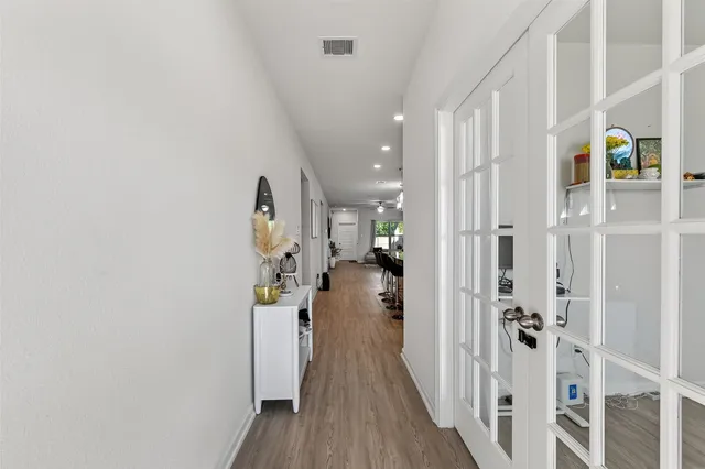 a view of a hallway with wooden floor and entryway