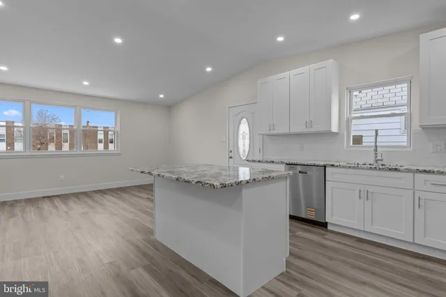 a kitchen with granite countertop a sink and cabinets