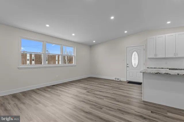 a view of empty room with wooden floor and window