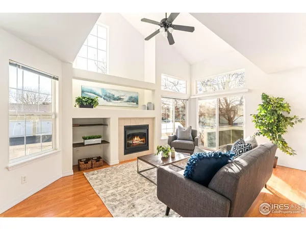 a living room with furniture a large window and a fireplace