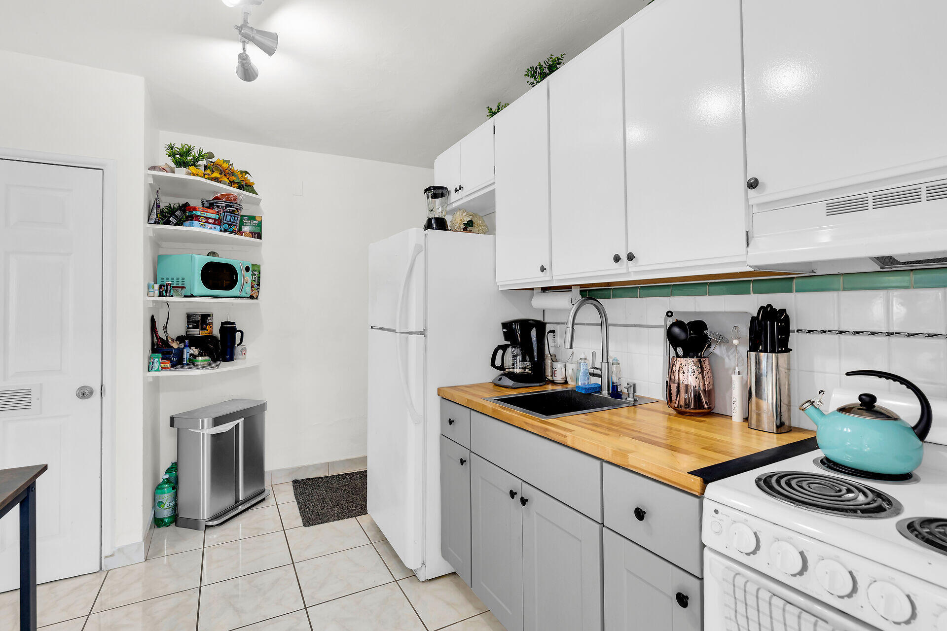 1119 Simonton Street, Unit A1 Key West, FL 33040 - Photo 9 of 18 a kitchen with granite countertop a white stove top oven and cabinets