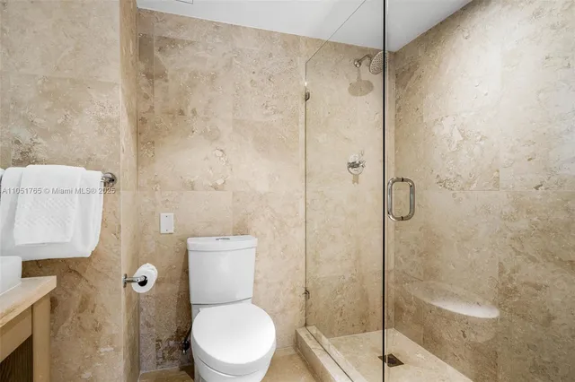 a white toilet sitting next to a shower