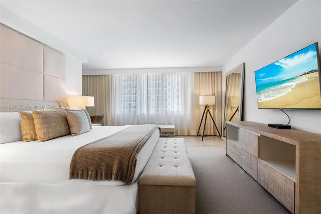 a bedroom with a bed and a flat screen tv