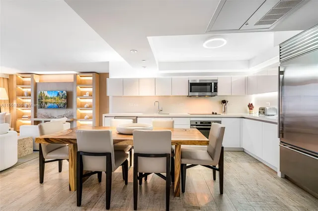 a kitchen with a table chairs microwave and refrigerator