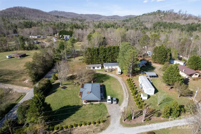 aerial view of a house with a yard and large trees