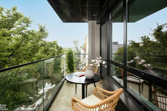 a balcony with chairs and a potted plant