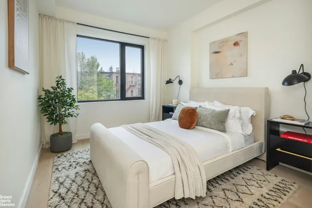a bedroom with a large bed and a potted plant