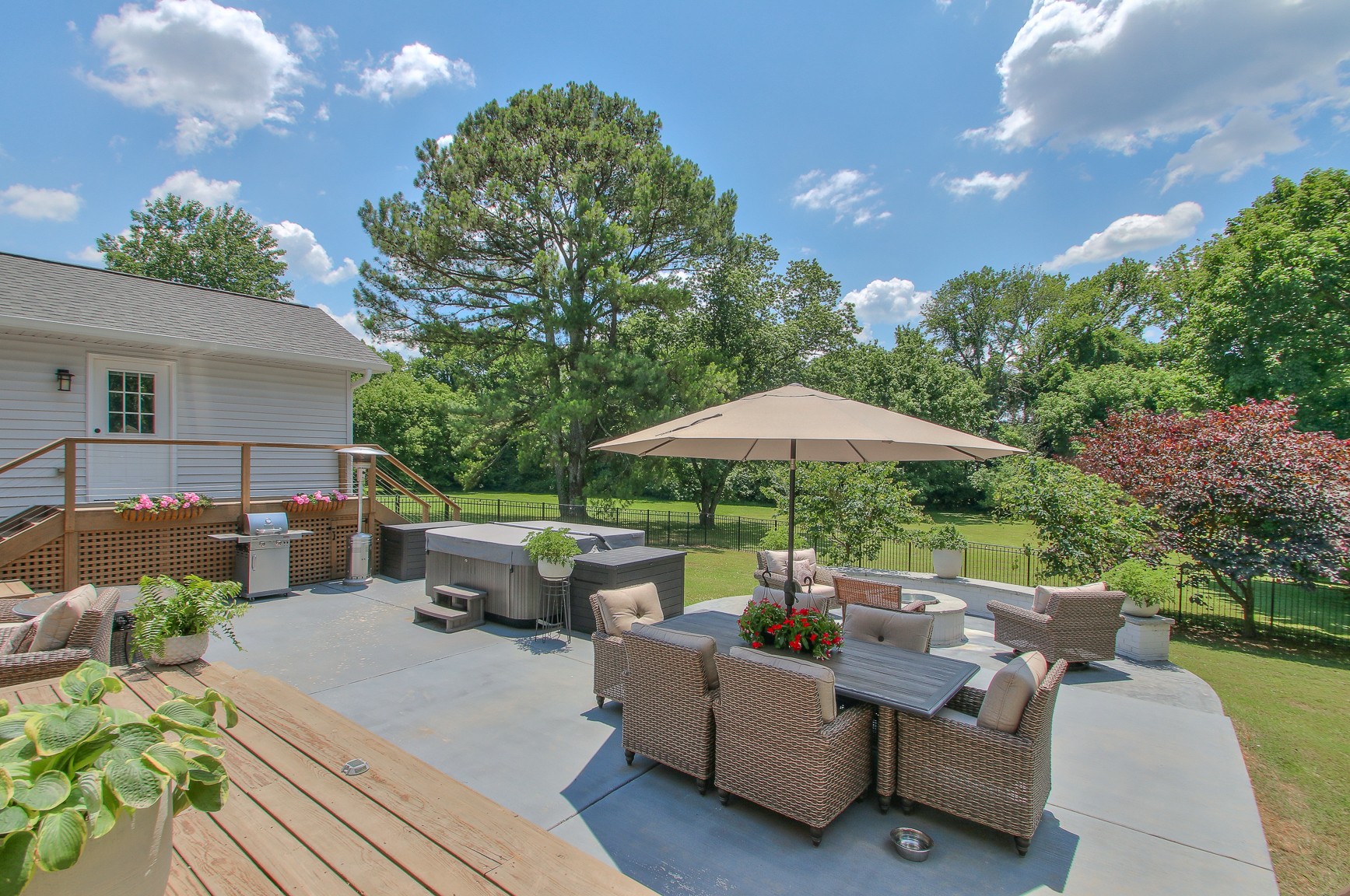 183 Lancaster Drive Franklin, TN 37064 - Photo 42 of 50 a view of a patio with couches table and chairs under an umbrella with a fire pit