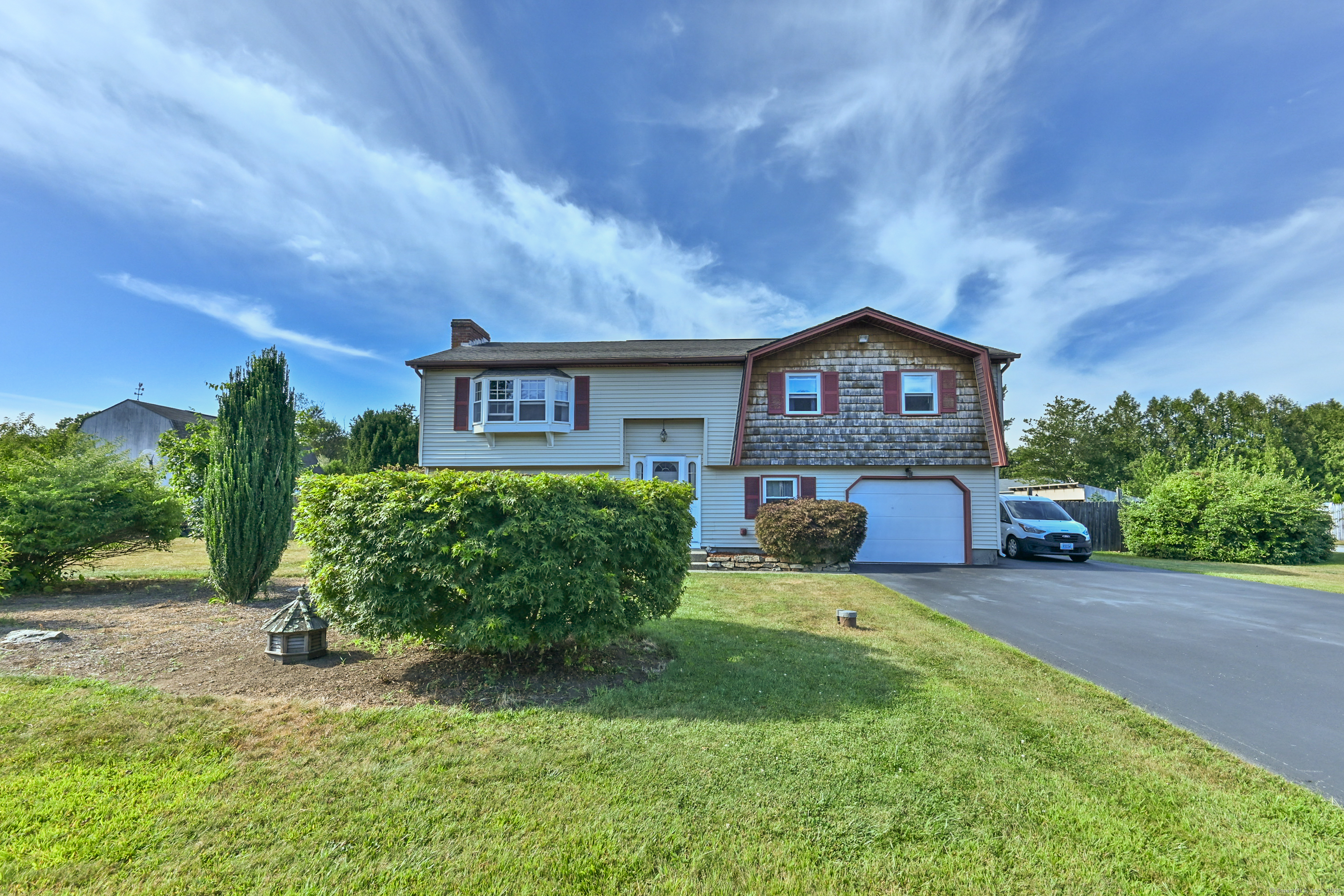a front view of a house with a garden and yard