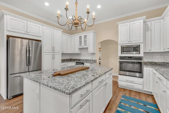 a kitchen with stainless steel appliances granite countertop a sink refrigerator and microwave