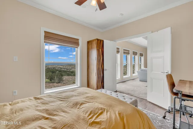 a bedroom with a bed and large windows