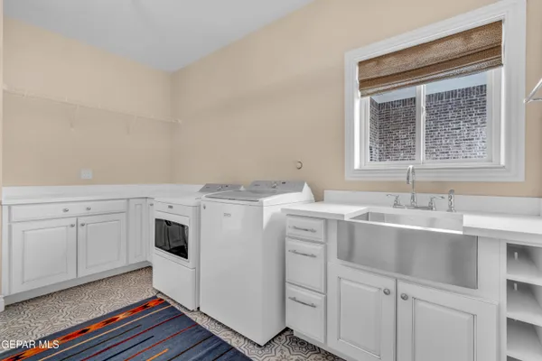 a utility room with cabinets washer and dryer