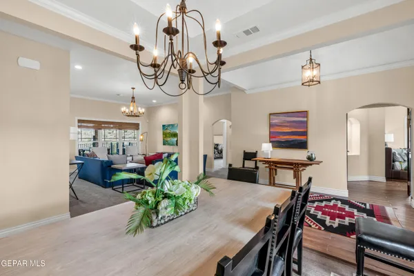 a view of a dining room with furniture a chandelier and wooden floor