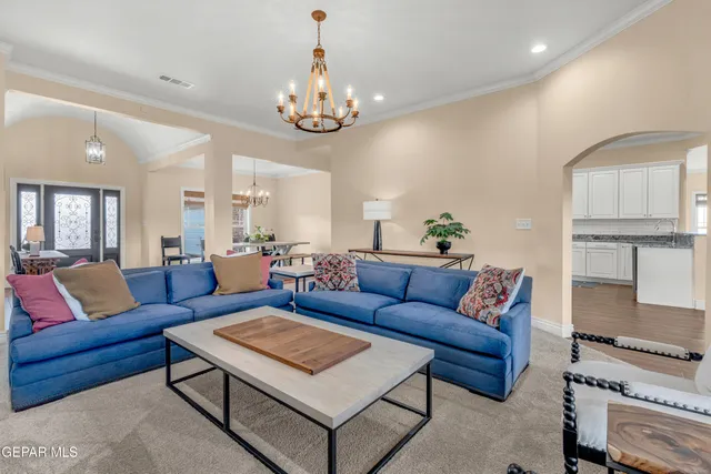a living room with furniture a rug and a chandelier