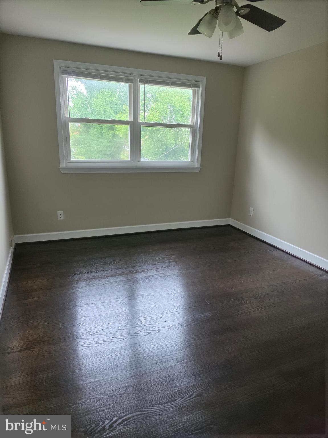 2028 Hillenwood Road Baltimore, MD 21239 - Photo 10 of 18 an empty room with wooden floor and windows