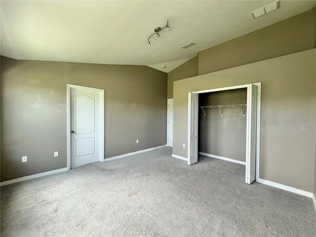 an empty room with closet and a bathroom