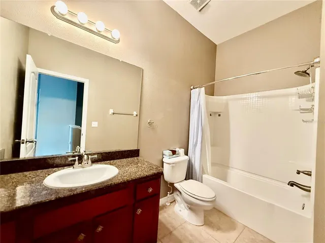 a bathroom with a granite countertop sink toilet a mirror and shower