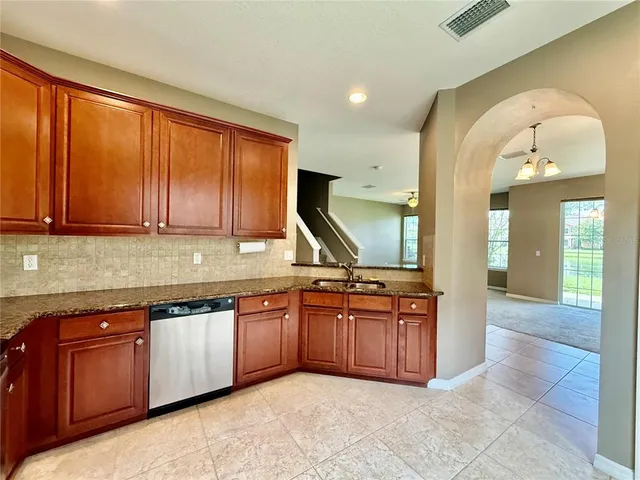 a view of a kitchen with stainless steel appliances granite countertop a stove and a sink