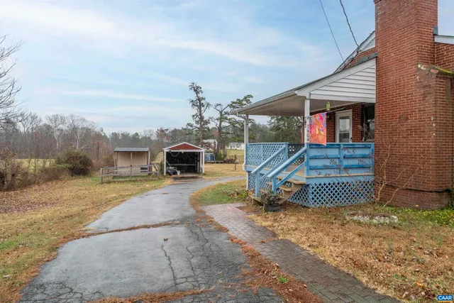 a view of a house with a backyard and a tree