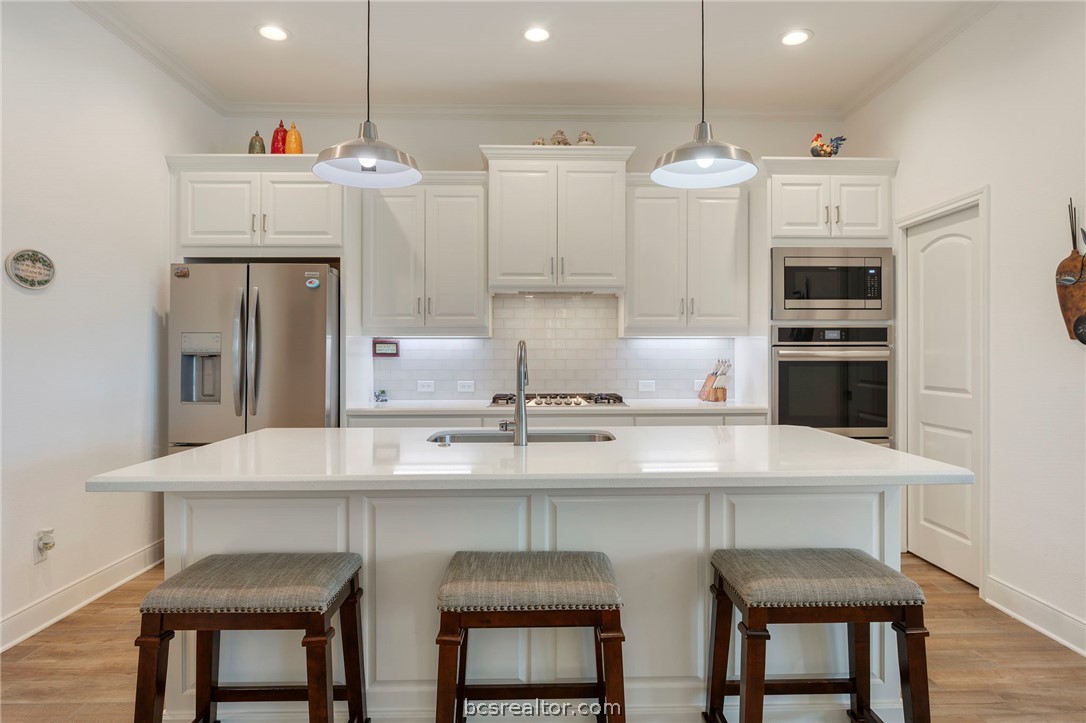 3500 Abingdon Cove Bryan, TX 77808 - Photo 3 of 23 a kitchen with stainless steel appliances a table and chairs in it