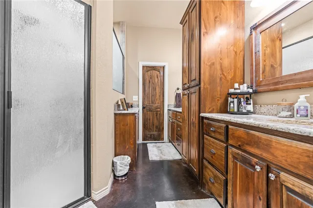 a bathroom with a granite countertop shower and a mirror