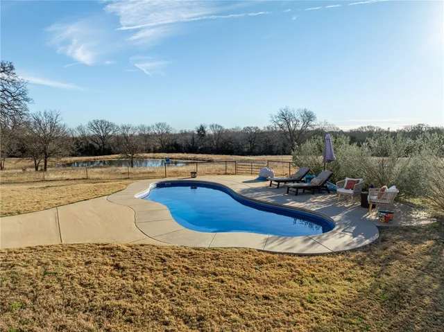 a view of a house with backyard and sitting area