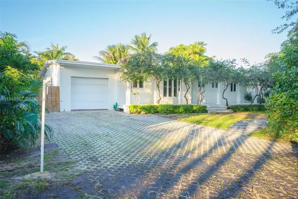 front view of a house with a yard and potted plants