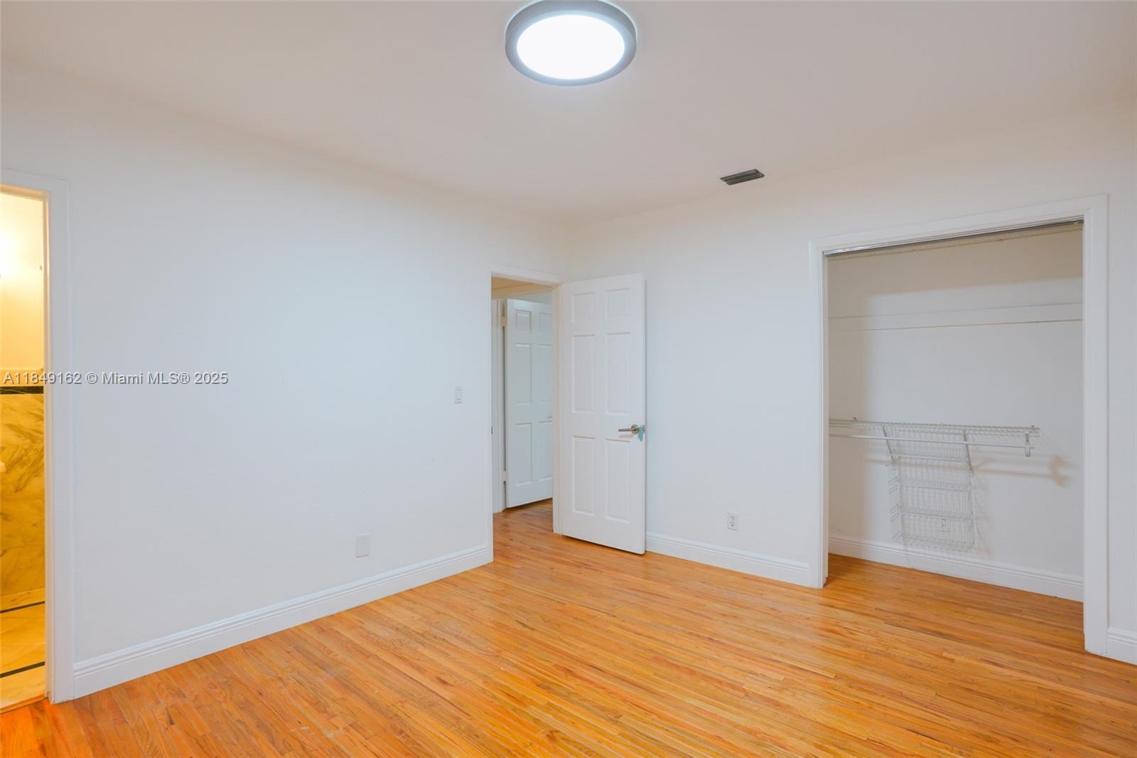 355 Redwood Lane Key Biscayne, FL 33149 - Photo 31 of 34 a view of empty room with wooden floor and fan
