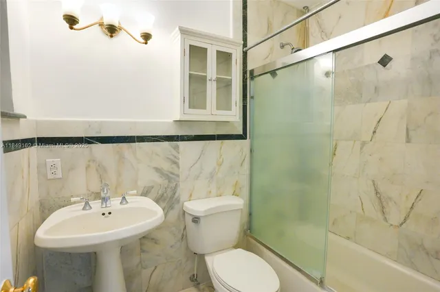 a bathroom with a sink mirror toilet and shower