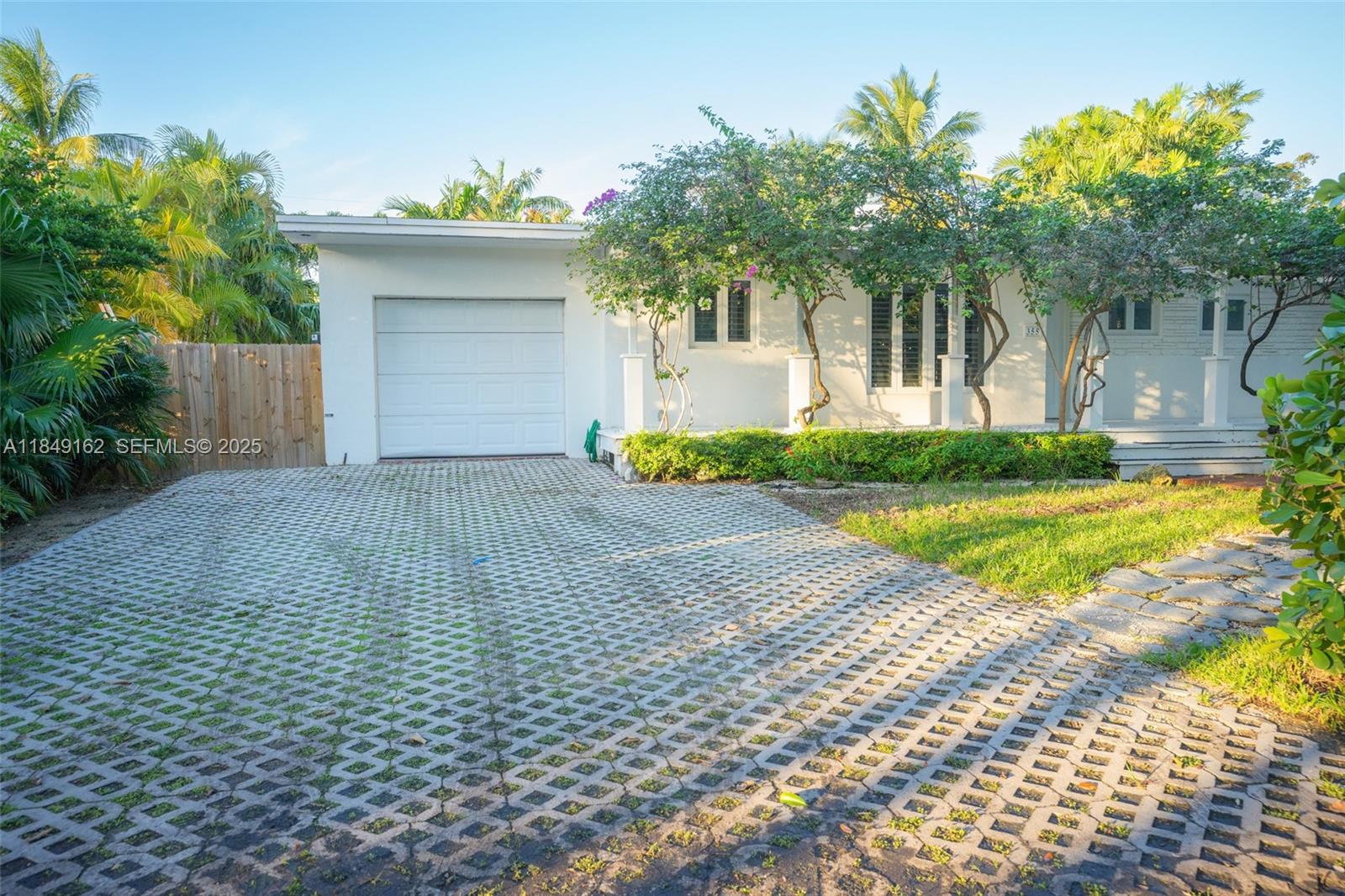 355 Redwood Lane Key Biscayne, FL 33149 - Photo 5 of 34 a front view of a house with a yard and a garage